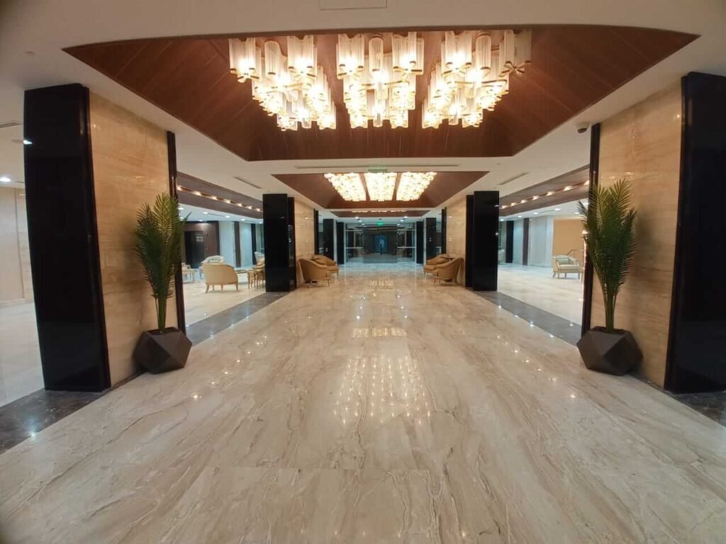 مدخل فندقي فخم من ضمن مشاريع تشطيبات في مصر نفذتها شركة بيت تايكون، يظهر جودة الأرضيات الرخامية والأسقف المعلقة.