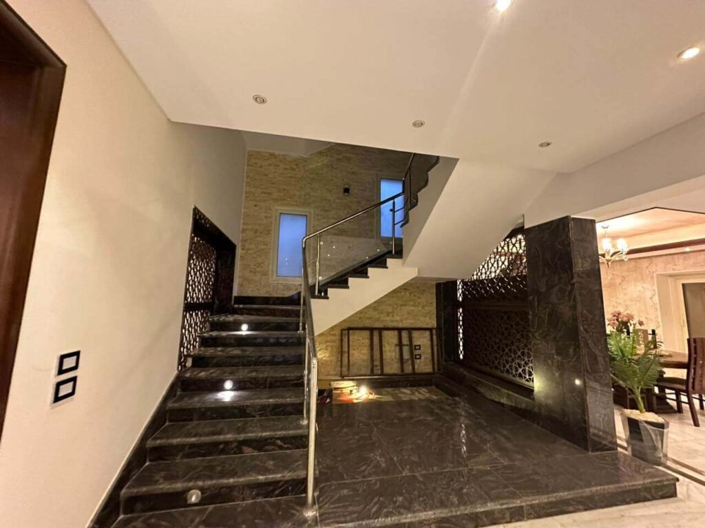 تصميم وتنفيذ سلم داخلي في فيلا مع درابزين من الزجاج المقسّى كجزء من مشروع تشطيب متكامل