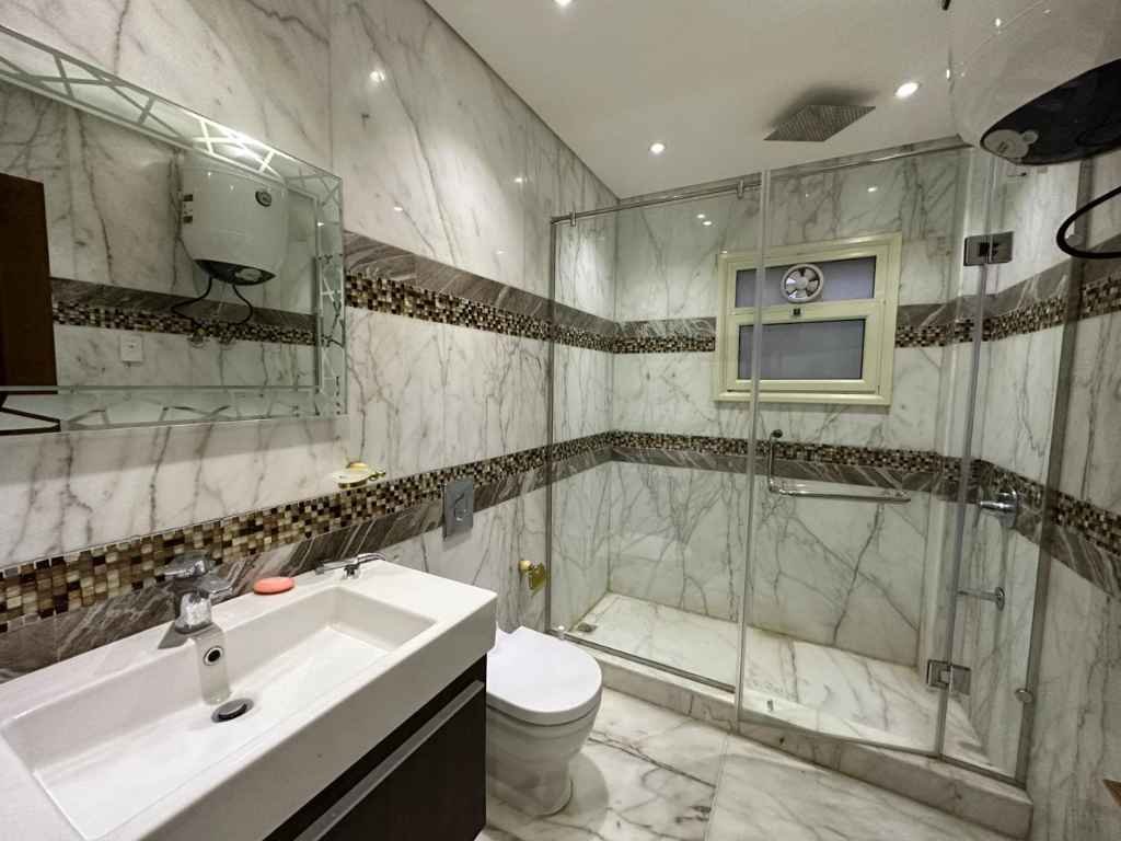 تشطيب حمام في فيلا بوحدات تخزين عصرية وبورسلين عالي الجودة على الجدران والأرضيات