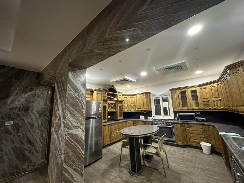 مطبخ فيلا بتصميم مفتوح (أمريكي) بعد اكتمال أعمال التشطيب، يوضح دقة تركيب الوحدات والأجهزة