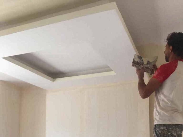 عامل يقوم بمعجون وتشطيب فواصل سقف جبس بورد في فيلا